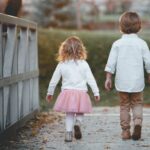 boy beside girl walking near railing