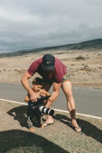 man and child holding preofessionalc amera