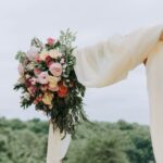 bouquet of assorted-color flowers hanged on brown plank with white textile